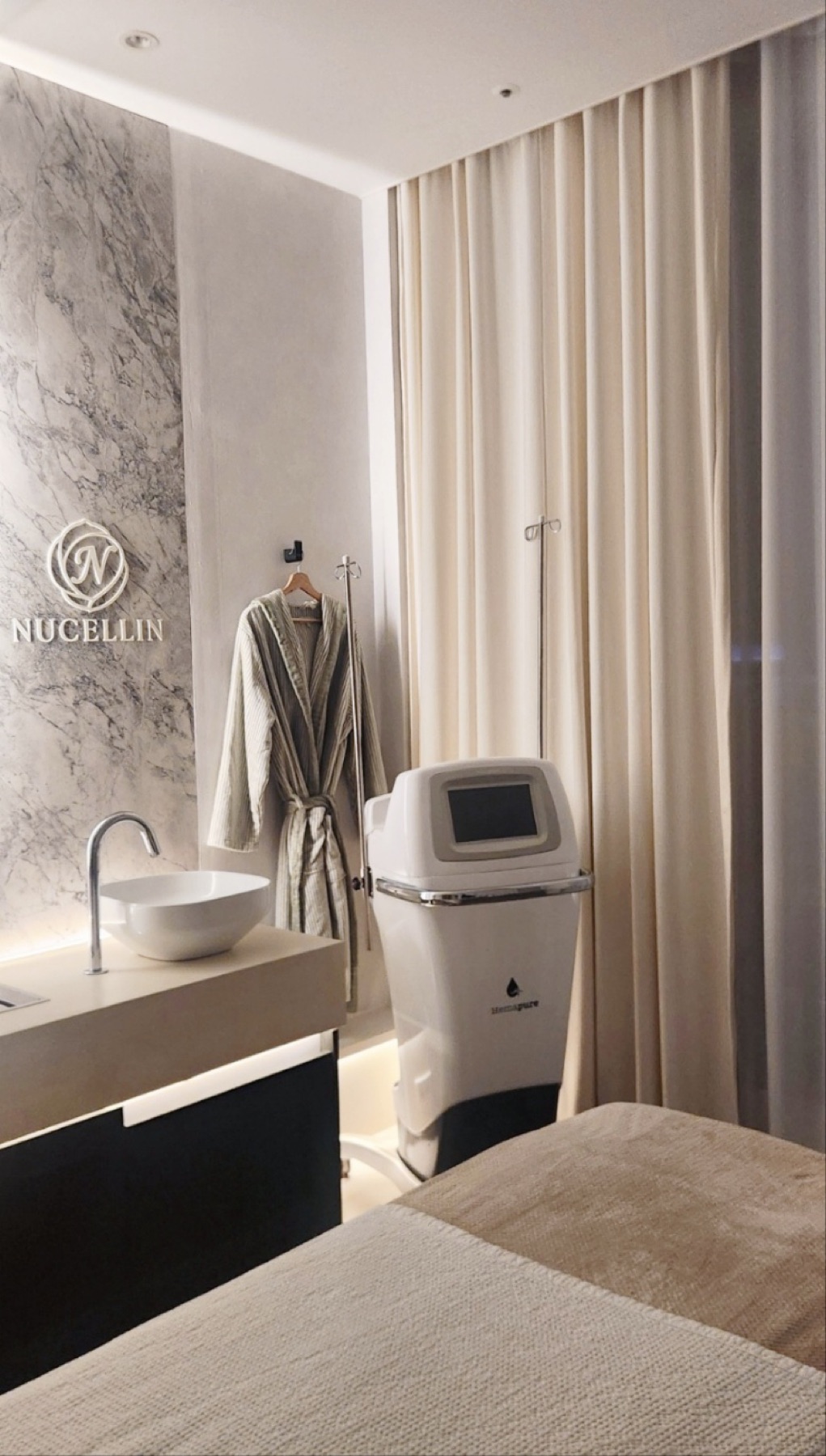 Treatment room with marble logo wall at Nucellin Orthopedic Clinic in Seoul